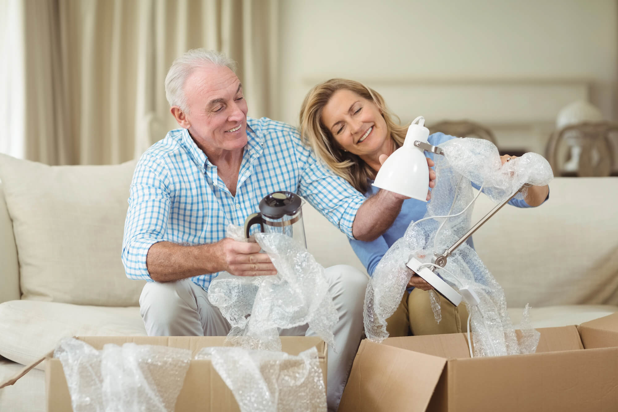 Freundliche Helfer tragen Umzugsgut sicher in das neue Zuhause einer Seniorin